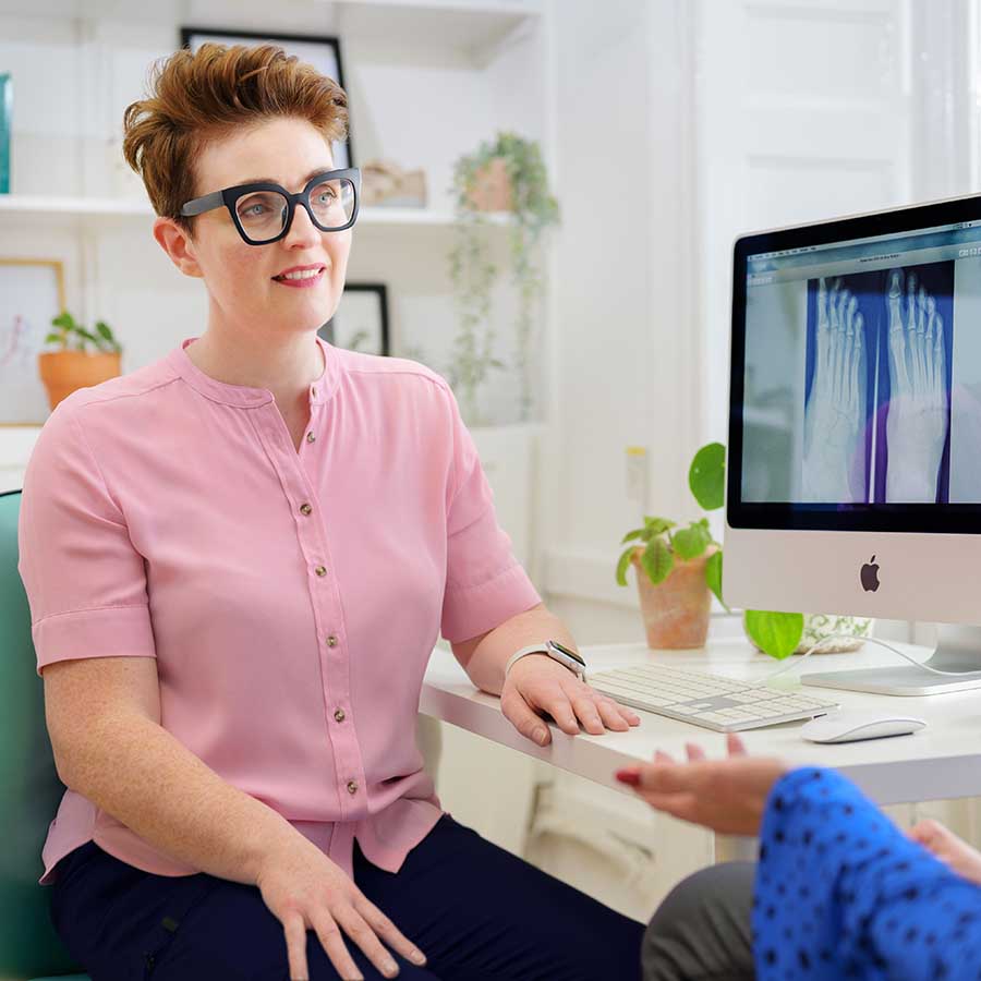 SO Podiatry - 3176 - Stephanie The Podiatrist In Consultation With Patient Looking At X-Ray Results