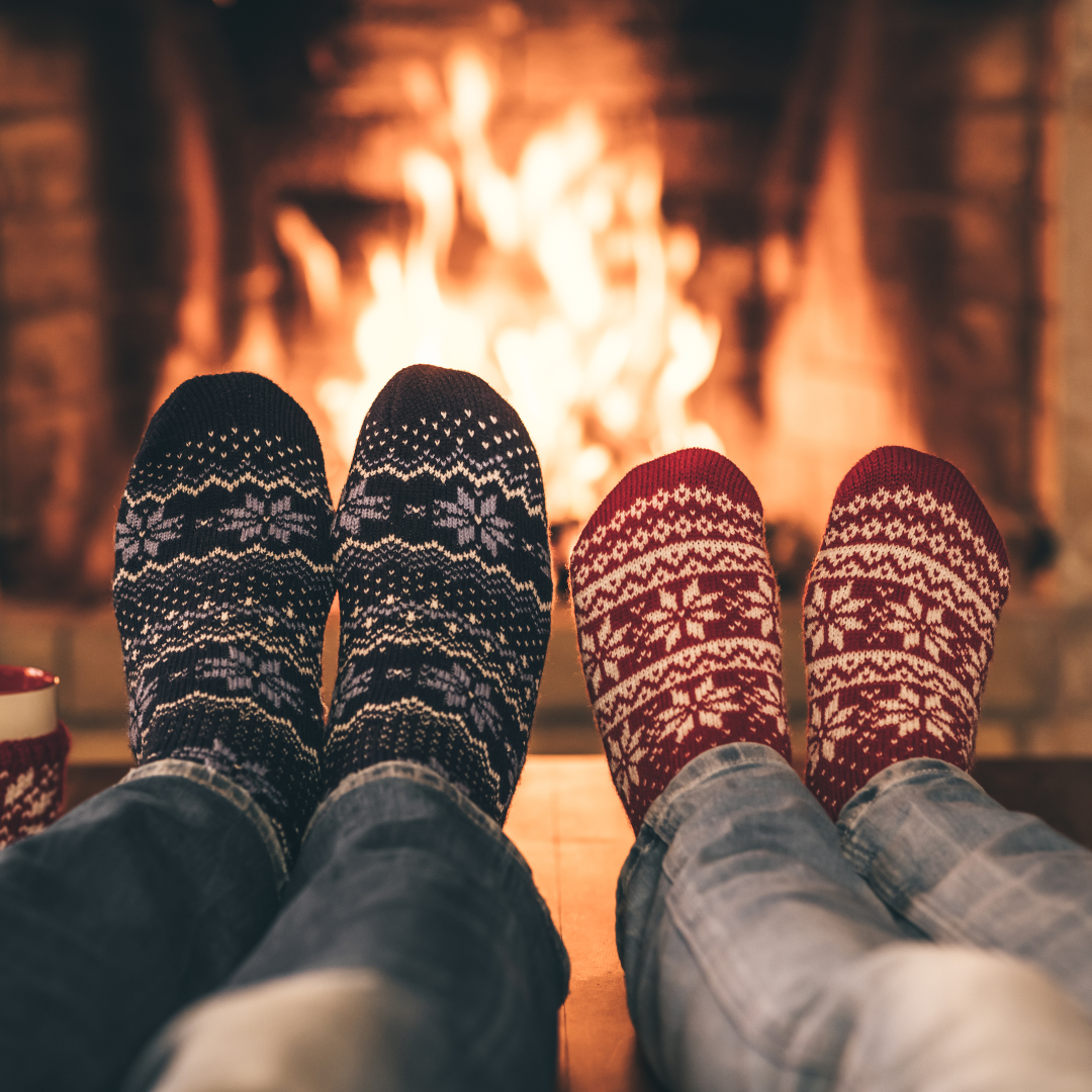 Image of feet in wooly socks by the fire.